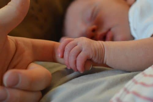 Bebé agarrando dedo de su padre