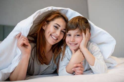 Madre y niño cubiertos por una sábana
